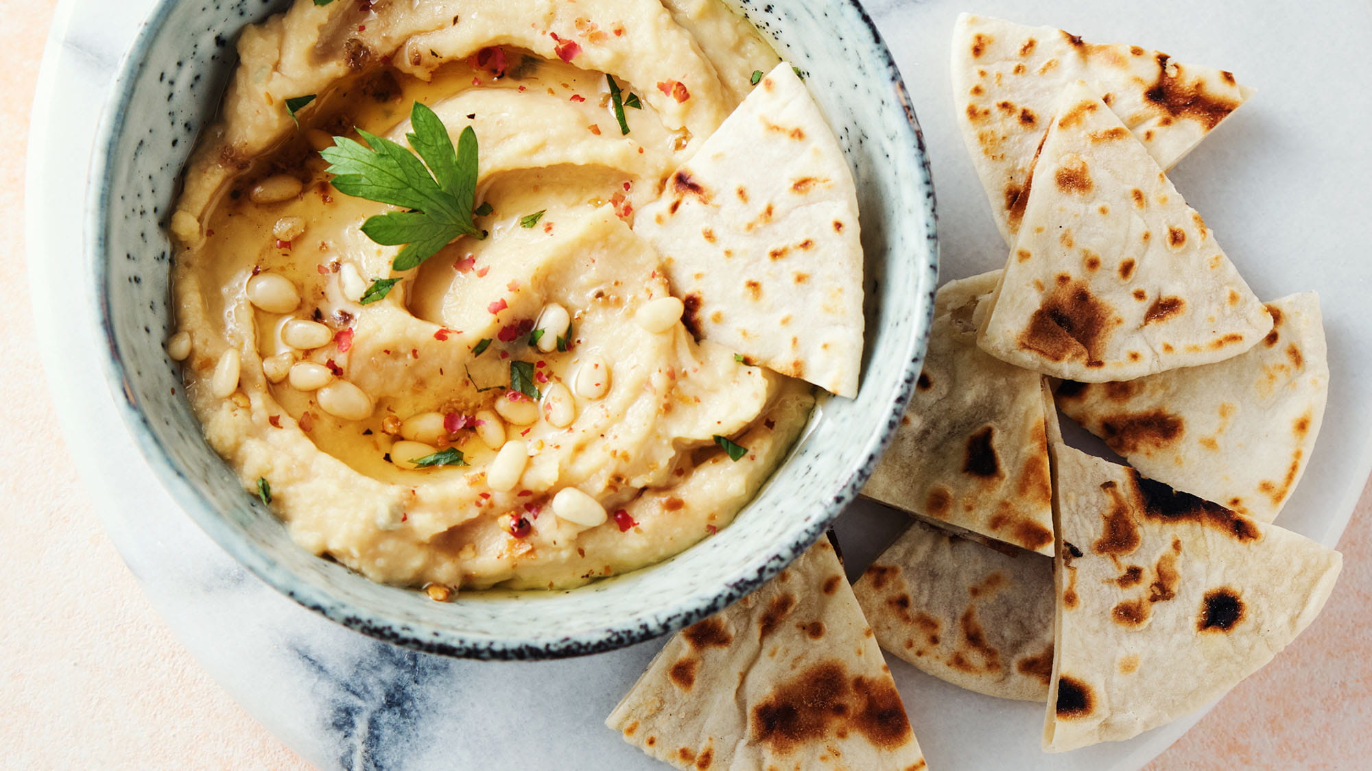 Huisgemaakte hummus met pijnboompitten en pitabroodjes