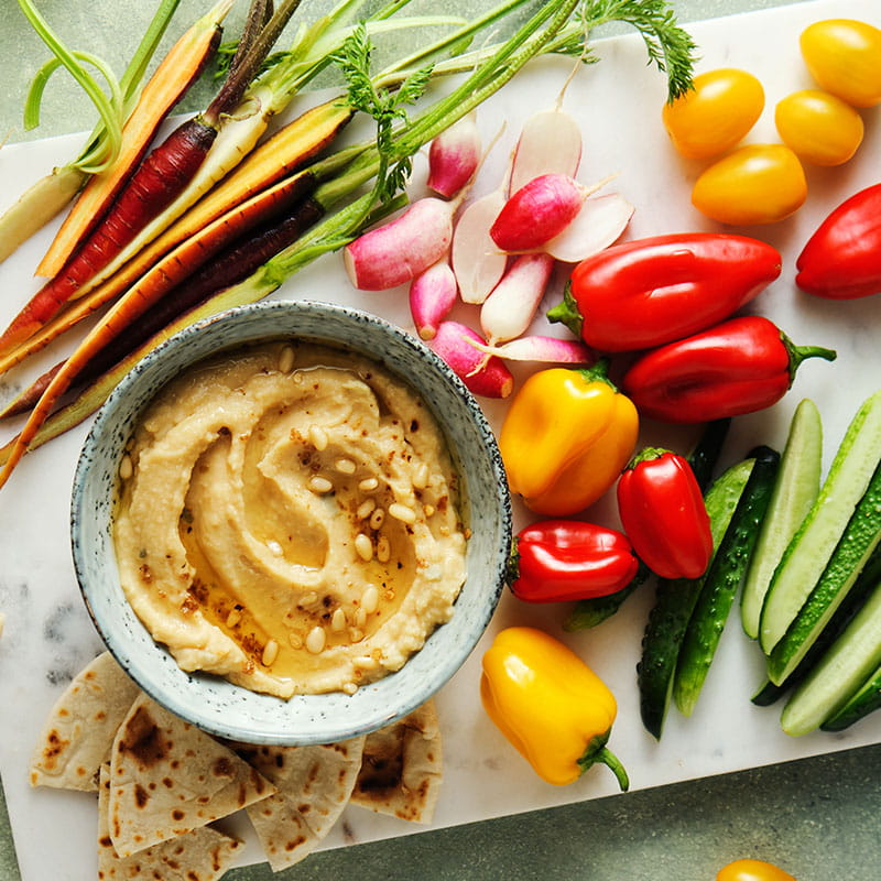 HuisgemaaktehummusmetkruidenpijnboompittenengroenteschotelmetregenboogReceptimage800x800