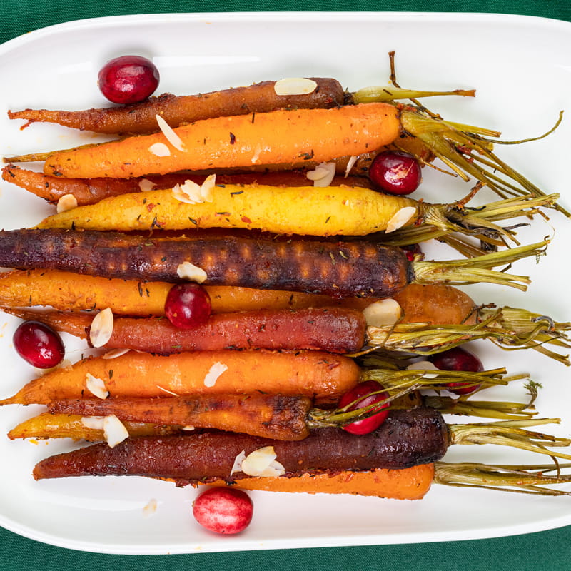 Kleurrijke, geroosterde wortels met harissa, cranberry's en amandelvlokken
